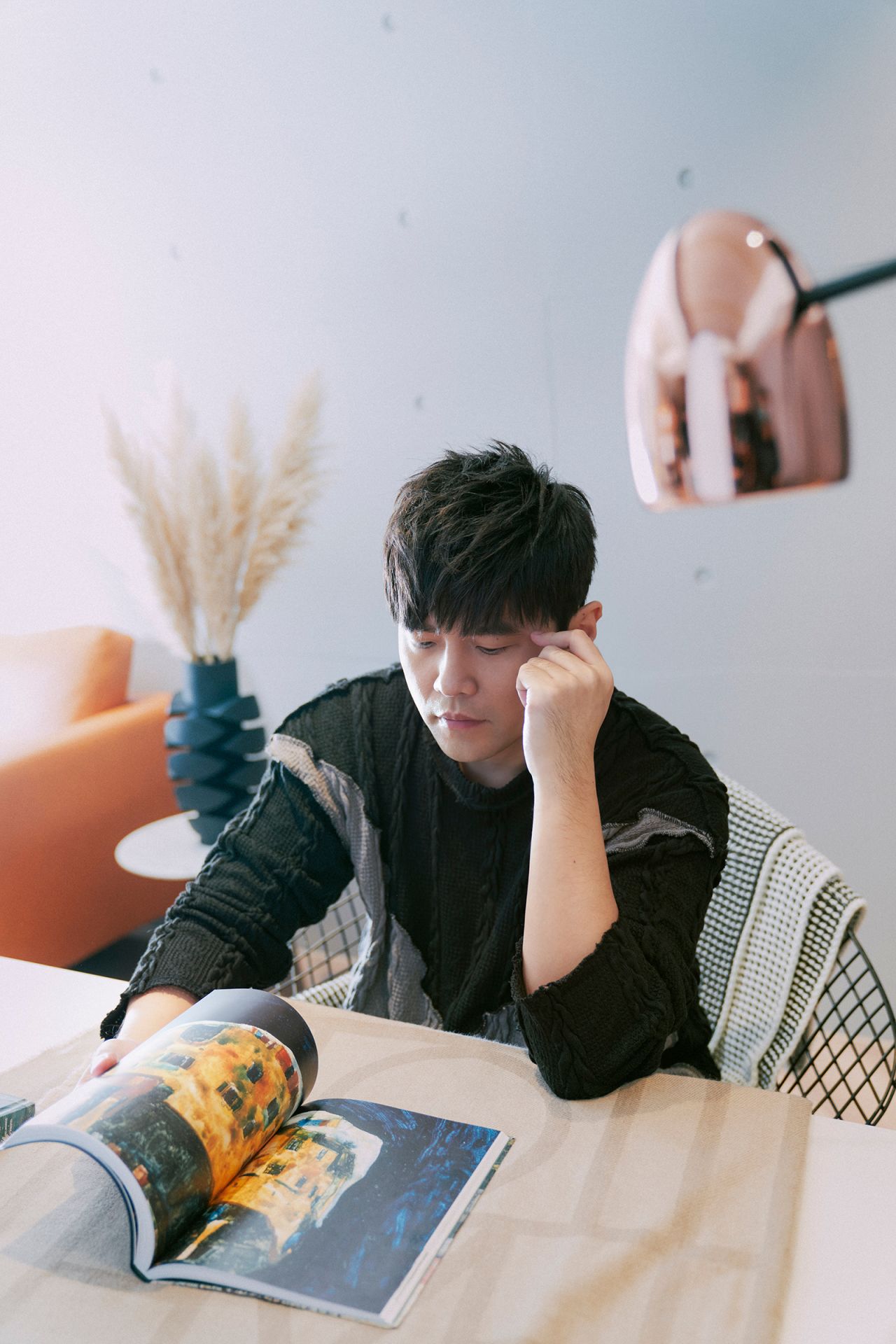 Jay Chou reading an art book in a promotional shot for his recent collaboration with Sotheby's.