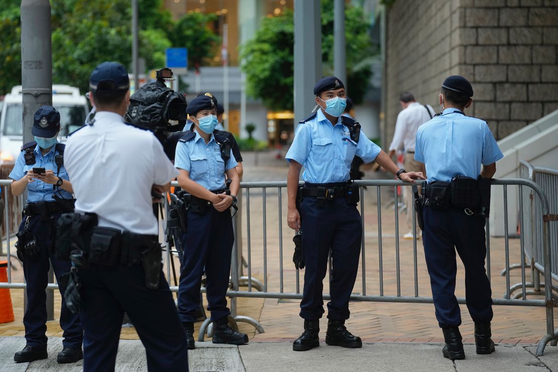 Police officers stand guard as Tong Ying-kit arrives at a court in Hong Kong on June 23.
