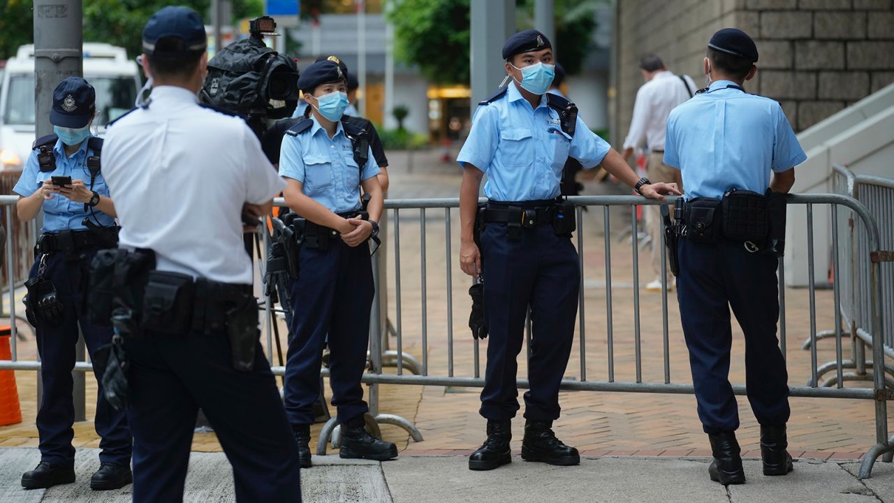 Police officers stand guard as Tong Ying-kit arrives at a court in Hong Kong on June 23.