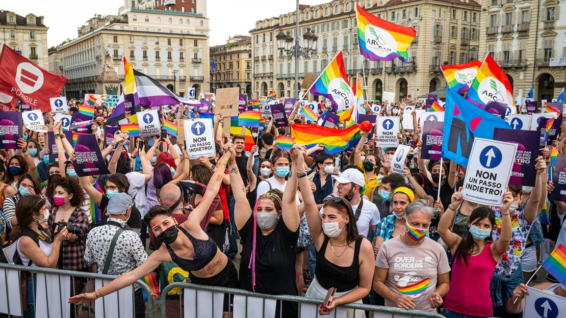 People hold placards and rainbow flags during a demonstration in support of the Zan law in Turin, Italy, on June 5.