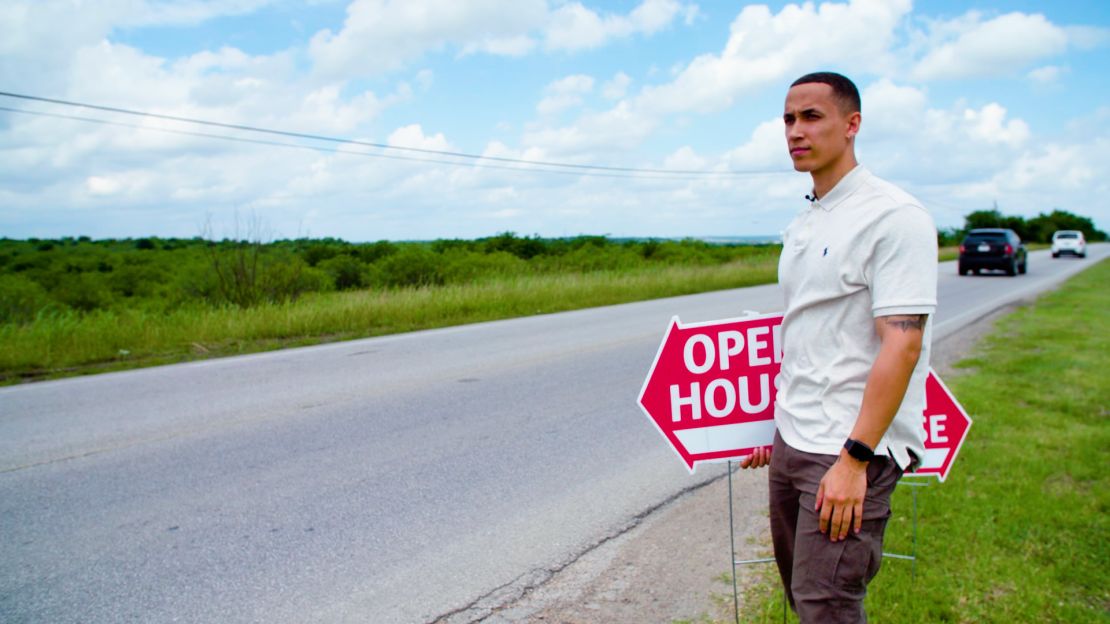 Sebastian Battle puts up signs for an open house he's hosting in the Austin-suburb of Manor, Texas.