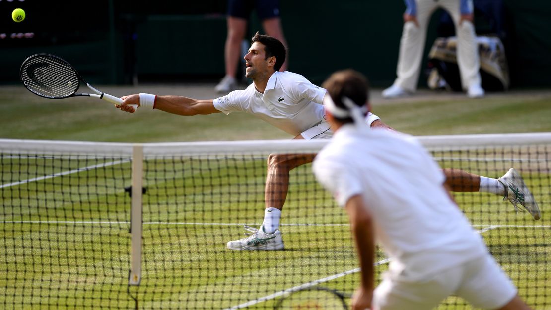Djokovic stretches to play a forehand against Federer.