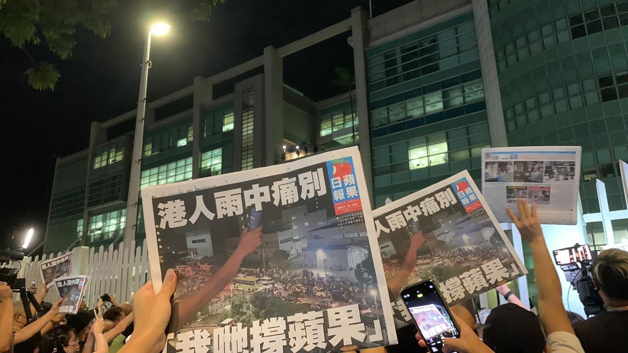 Free copies of the final Apple Daily issue being handed out to supporters through the gates in Hong Kong on July 23.