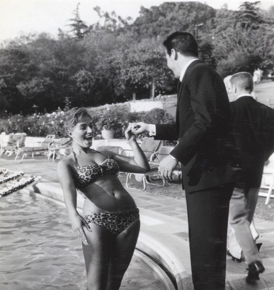 Every social event was an opportunity to catalog the details that would later give her novels an insider's voice. "She would observe things in life and then translate them into books," Collins' literary agent Morton Janklow says in "Lady Boss." "I could sometimes pick out the characters in her books who were based on real life people." Here, Collins is seen with actor Ron Randell at a 1956 pool party.