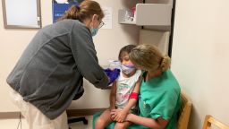 Ellie Bui, 6, receives her first dose of either the Pfizer vaccine or a placebo.