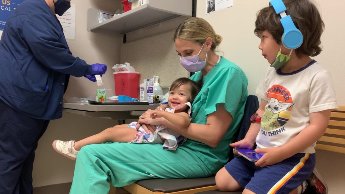 Sloane Bui, 14 months, laughs before getting her first shot of either a Covid-19 vaccine or a placebo.