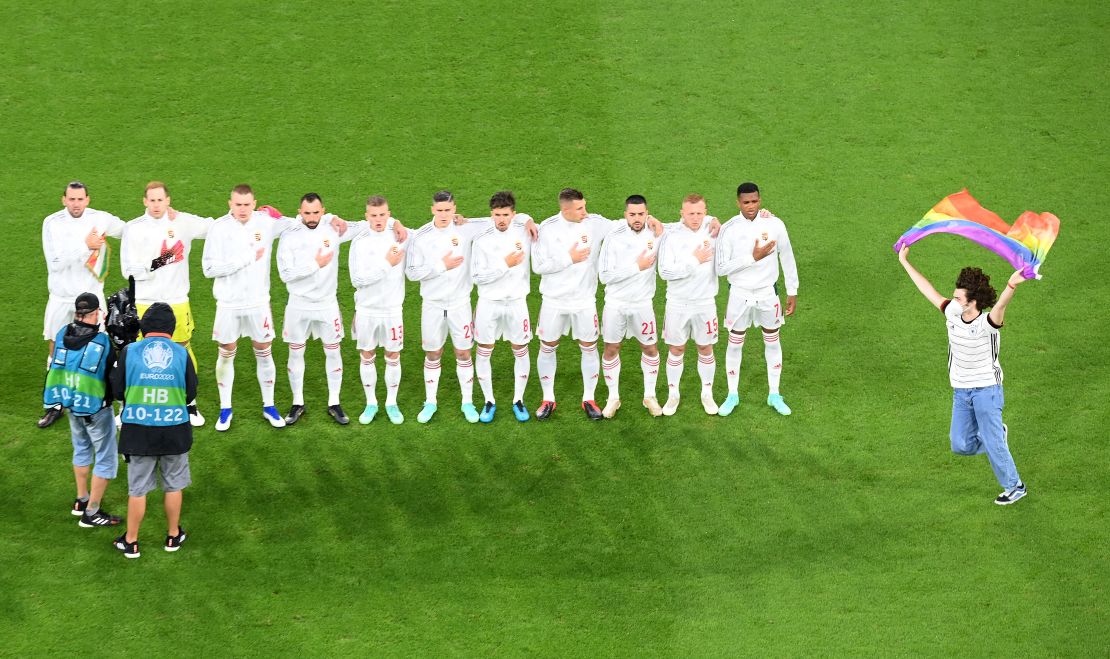 A pitch invader with a rainbow flag is seen on the pitch as the players of Hungary sing the national anthem prior to the Euro 2020 Group F match against Germany at thee Allianz Arena.