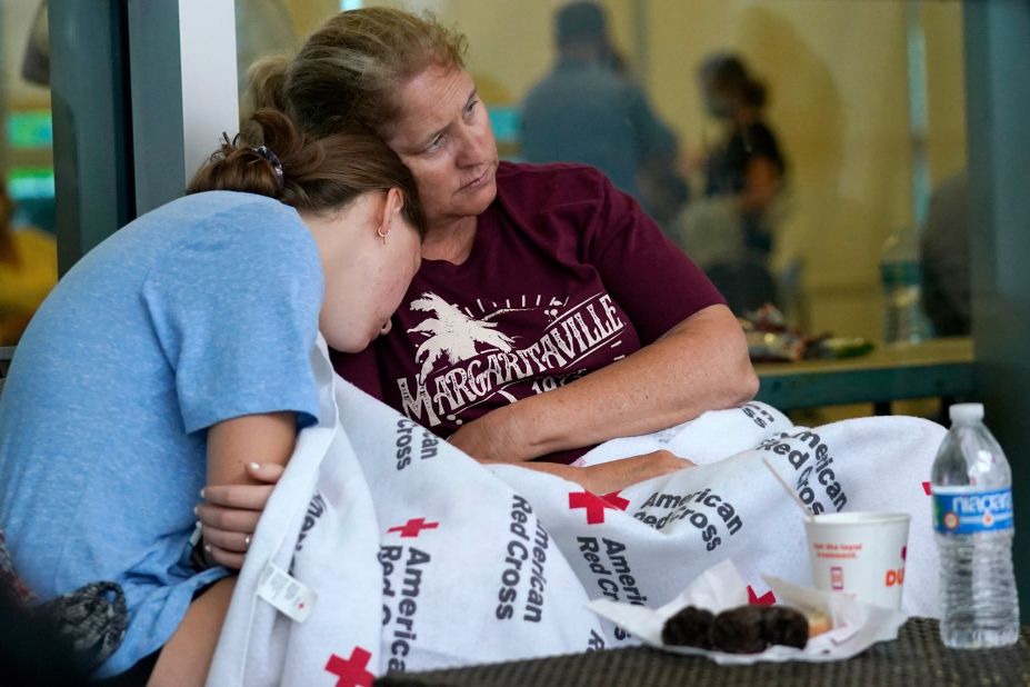 Jennifer Carr sits with her daughter as they and other evacuees wait for news at the family reunification center in Surfside.