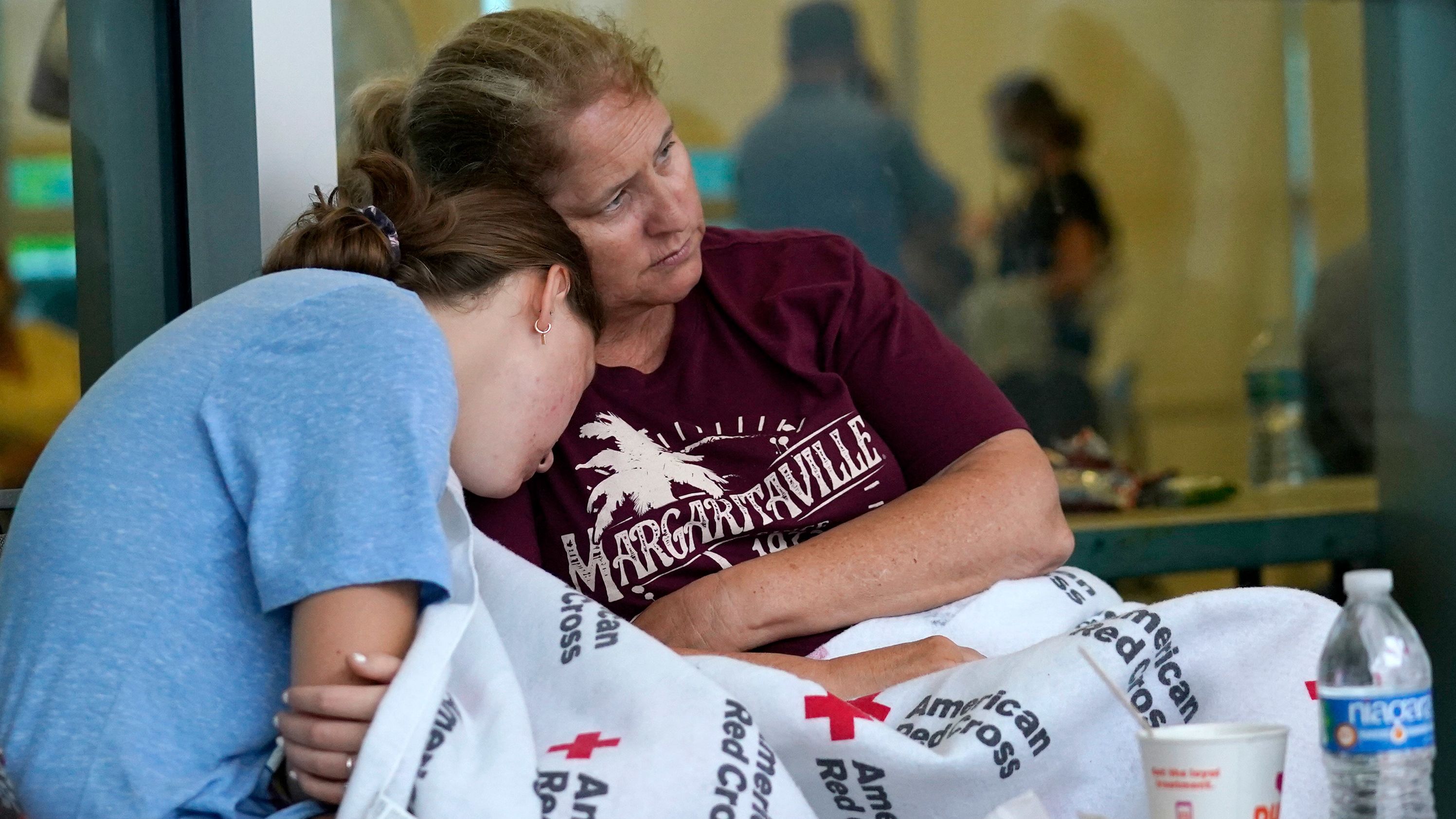 Jennifer Carr sits with her daughter as they and other evacuees wait for news at the family reunification center in Surfside.