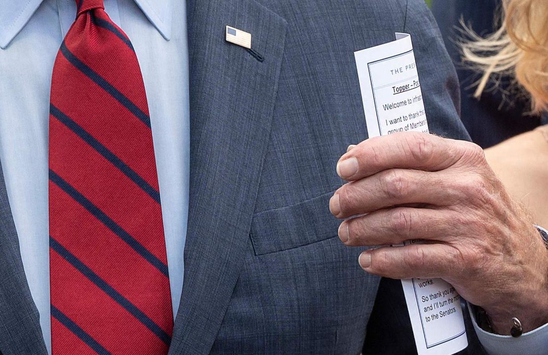 President Joe Biden holds a notecard as he speaks to the media outside the White House after a meeting with a bipartisan group of Senators on infrastructure negotiations on Thursday.