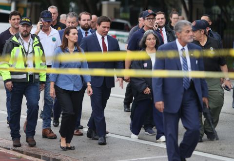 Florida Gov. Ron DeSantis, at center in the red tie, arrives to speak to the media on June 24. 