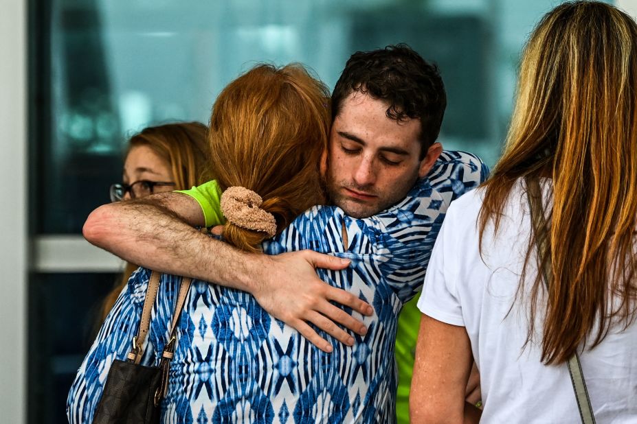 People hug at a family reunification center where evacuees were staying in Surfside.