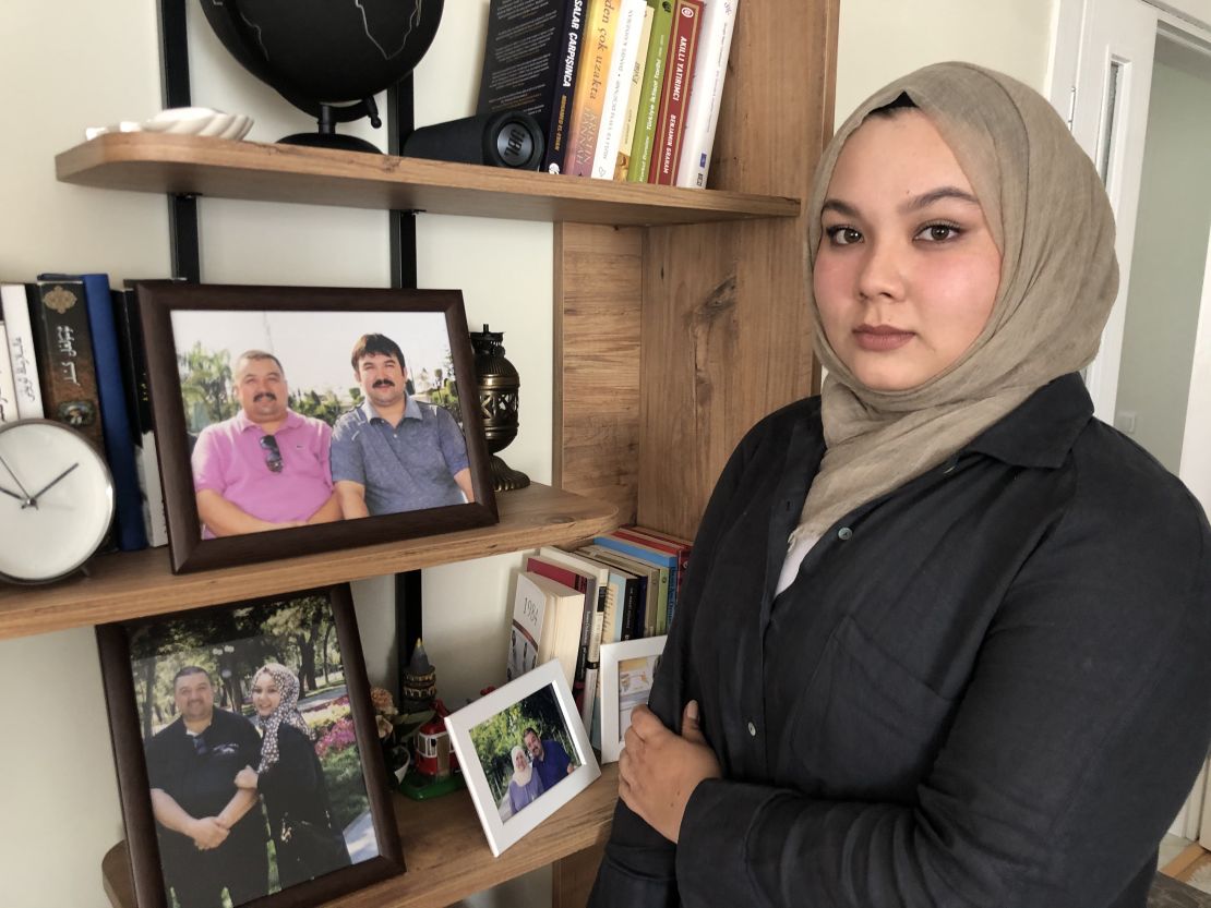 Dilsar Ablimit, 21, at her home in Turkey in June, with a photo of her father and uncle before they were detained.