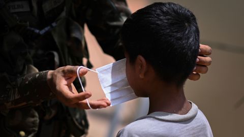 A member of the Brazilian Armed Forces puts a face mask on a child in the village of Urucu Jurua, Grajau, Maranhao state, Brazil, in October 2020.
