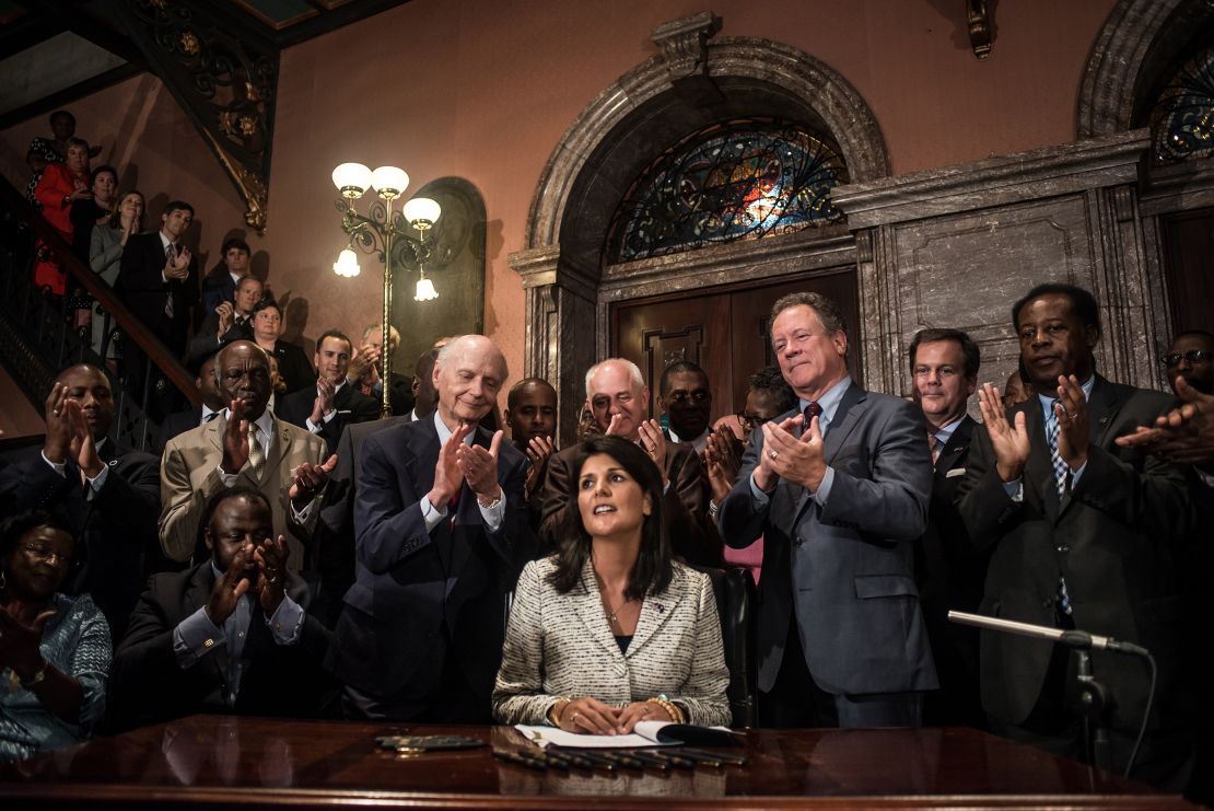 As governor of South Carolina,  Haley receives applause after signing a bill to remove the Confederate battle flag from the state house grounds in 2015. 