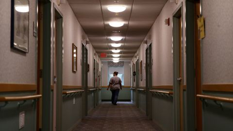 A licensed practical nurse walks down a hallway at an assisted living facility in Marlborough, Massachusetts, in August 2020.