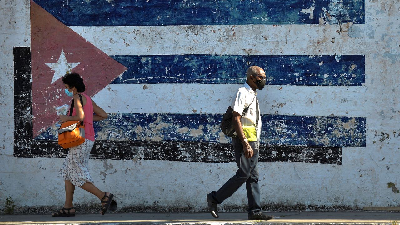 People walk near a mural depicting a Cuban flag in Havana, on April 16, 2021.