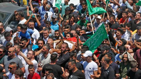 Mourners walk in a funeral procession with the body of human rights activist and critic of the Palestinian Authority Nizar Banat.