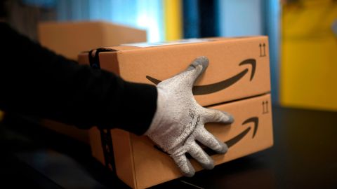 An employee carries a package at the distribution center of US online retail giant Amazon in Moenchengladbach, on December 17, 2019. (Photo by INA FASSBENDER / AFP) (Photo by INA FASSBENDER/AFP via Getty Images)