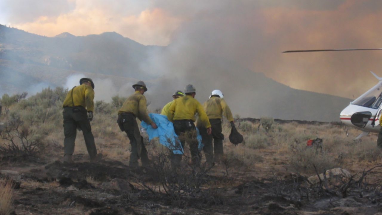 The Eldorado Hotshots medevac one of their own as Hump walks behind them during the New York Peak Fire in Nevada in 2006.