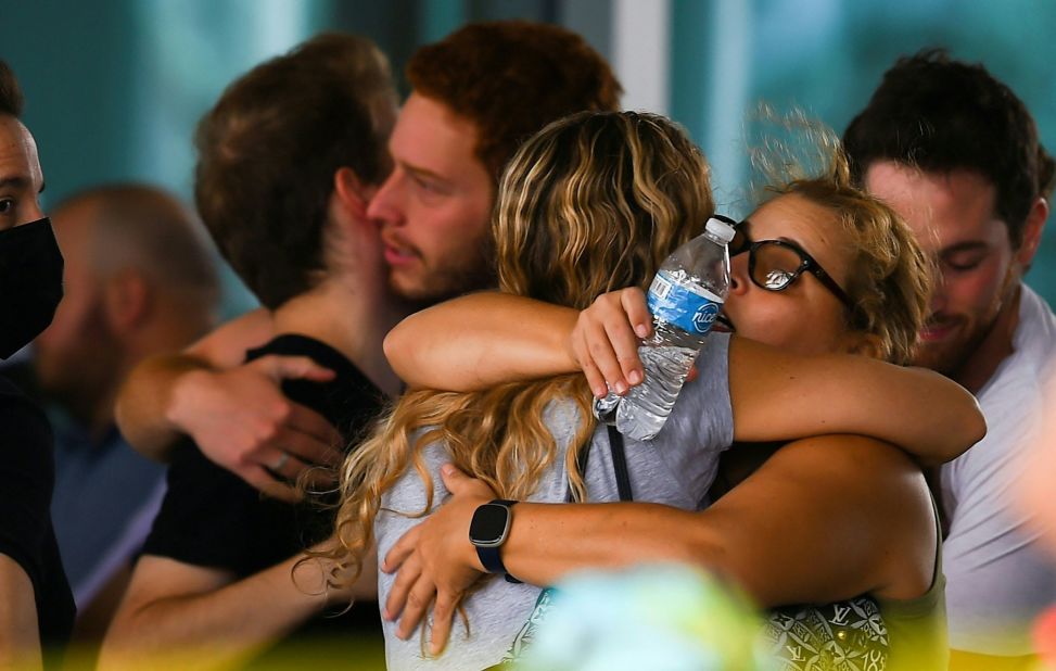 People hug June 25 as they wait for news about their relatives at a community center in Surfside.