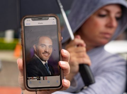 Toby Fried holds up a picture of her missing brother, Chaim Rosenberg, outside the Surfside Community Center on June 25.