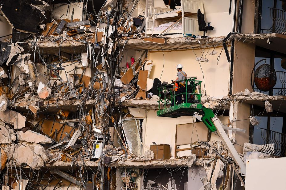 Rescue workers use a crane to inspect the damage.