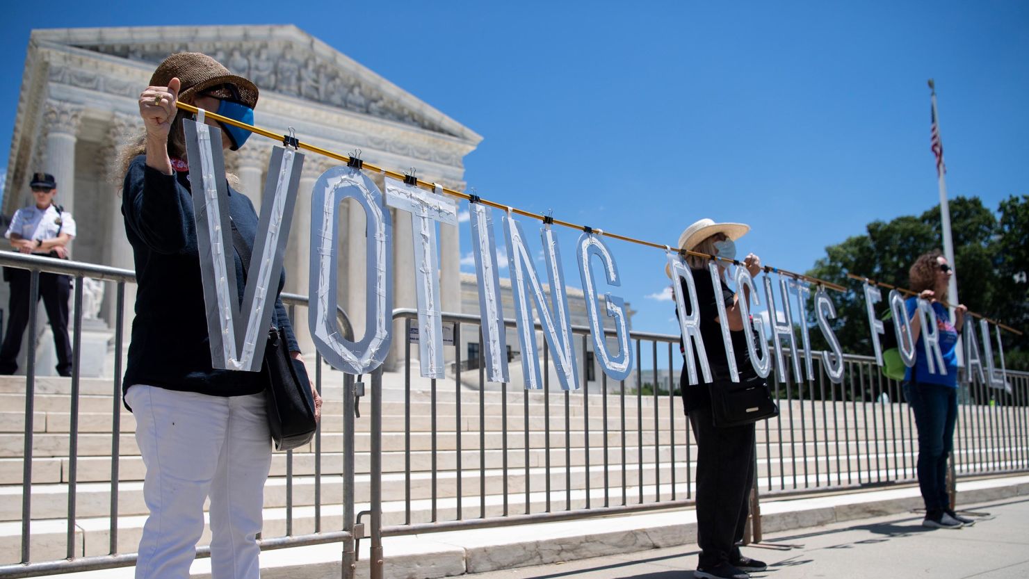 Demonstrators hold up a sign as they participate in the Moral March on Manchin and McConnell, Wednesday, June 23, 2021.