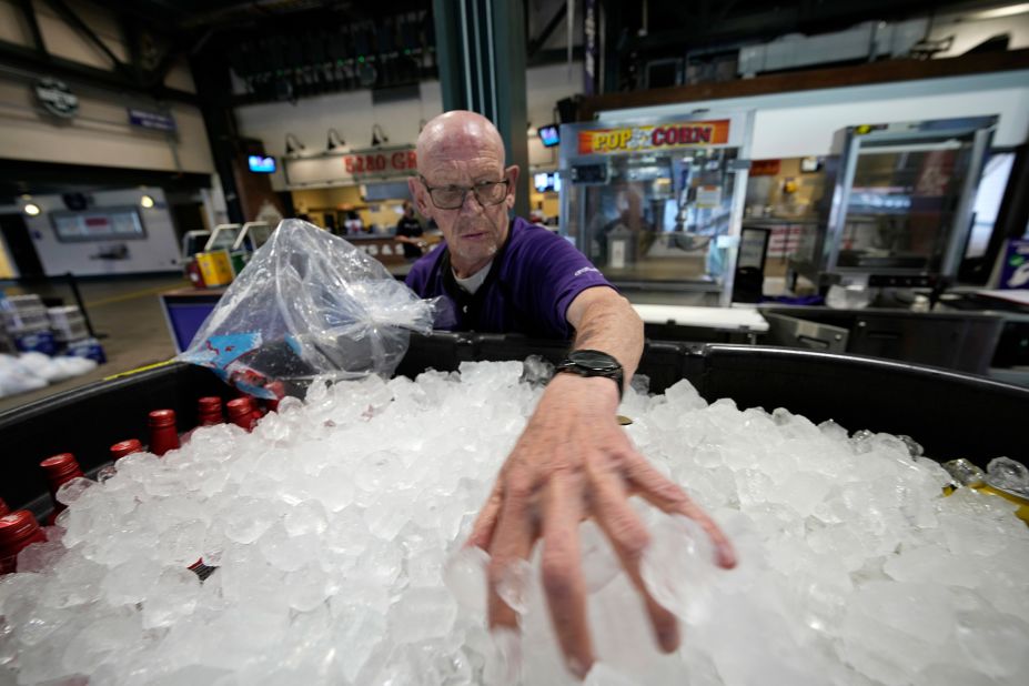 James Oehlerking spreads ice over a tub of bottled beer at Coors Field, the home of Major League Baseball's Colorado Rockies, on June 17. Temperatures were in the triple digits for a third straight day in Denver.
