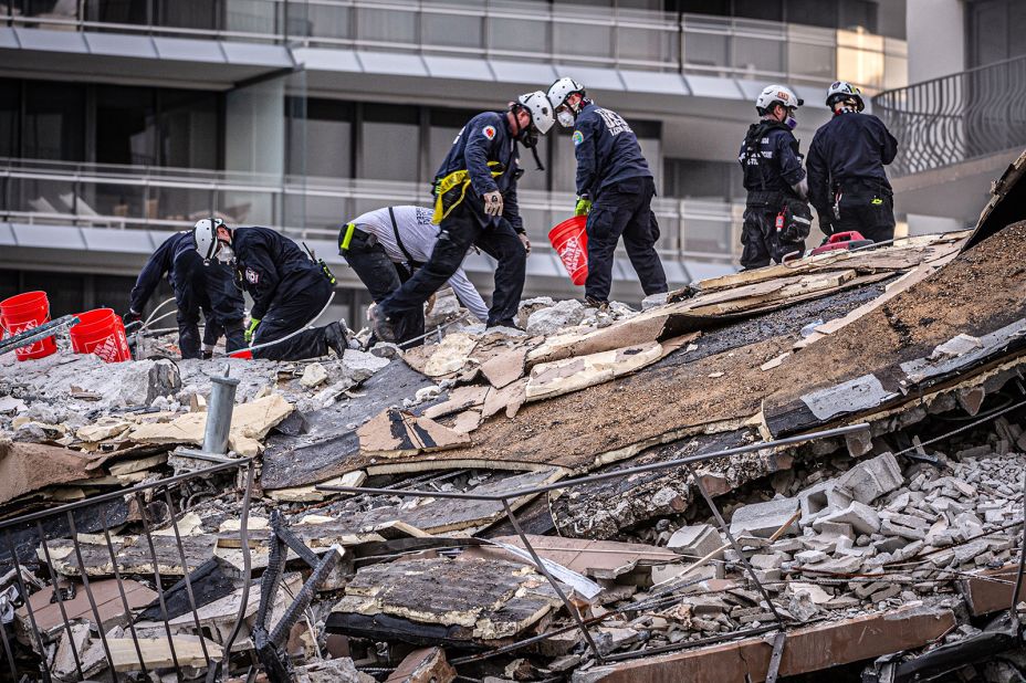 Members of a search-and-rescue team work in the rubble.