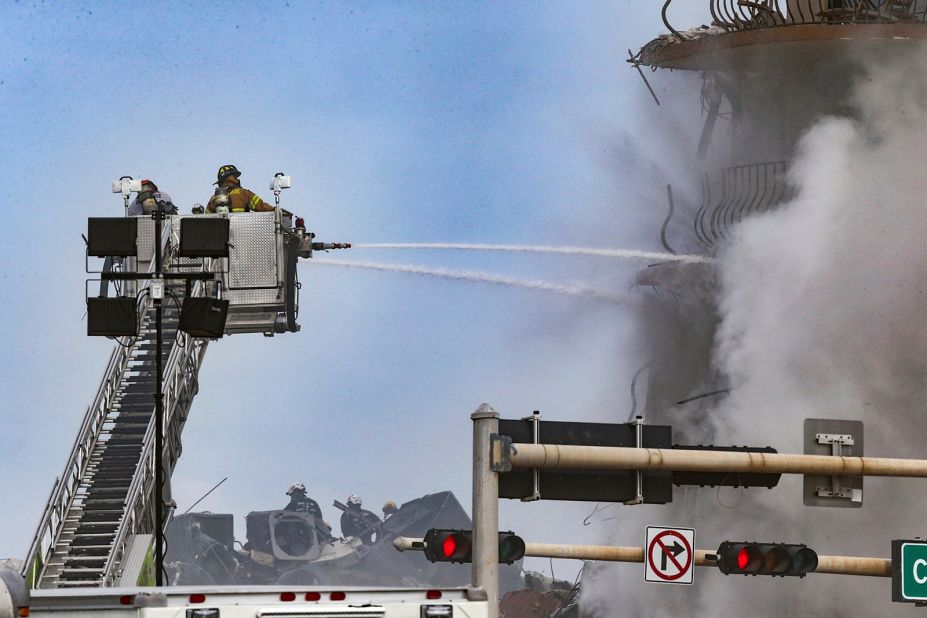 Firefighters battle a blaze at the collapse site.