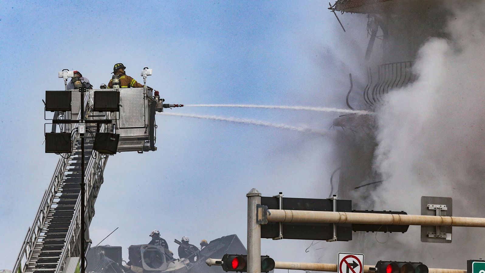 Firefighters battle a blaze at the collapse site.