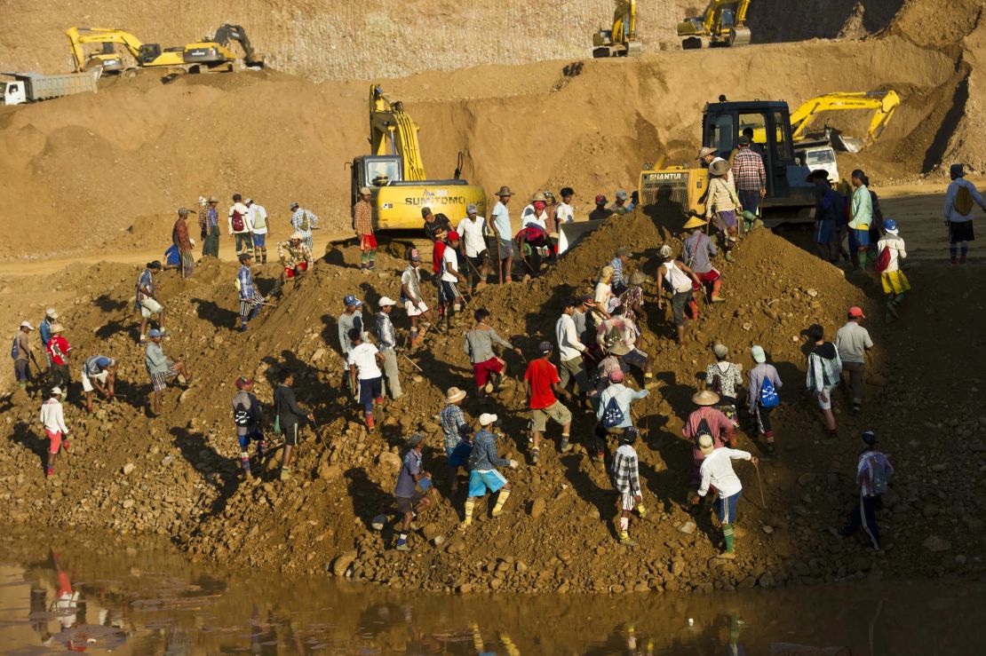 Freelance miners digging for raw jade stones in piles of waste rubble dumped by mechanical diggers, next to a jade mine in Hpakant on October 4, 2015.