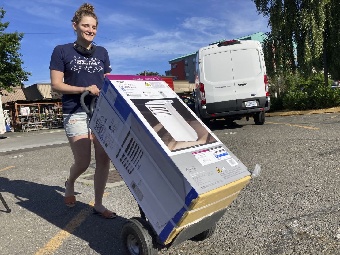 Sarah O'Sell takes her new air conditioner to her apartment in Seattle on Friday.