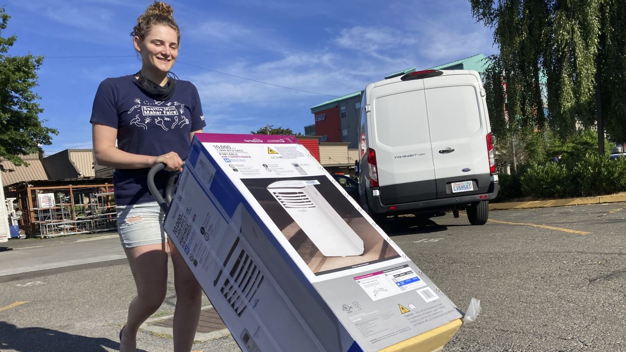 Sarah O'Sell takes her new air conditioner to her apartment in Seattle on Friday.