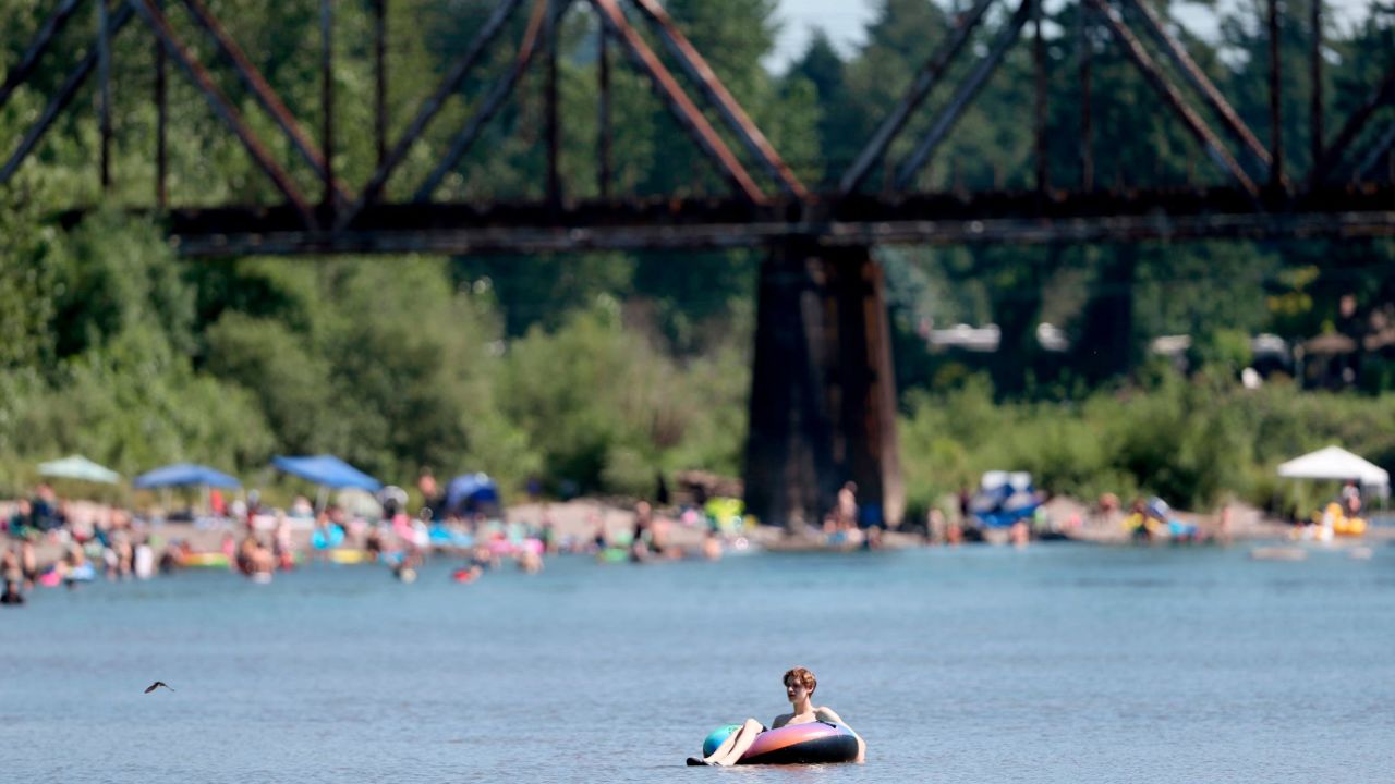 People gather at the Sandy River Delta in Oregon to cool off Friday. 