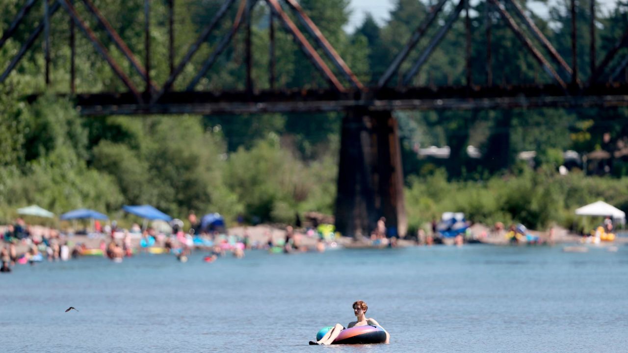 People gather at the Sandy River Delta in Oregon to cool off Friday.