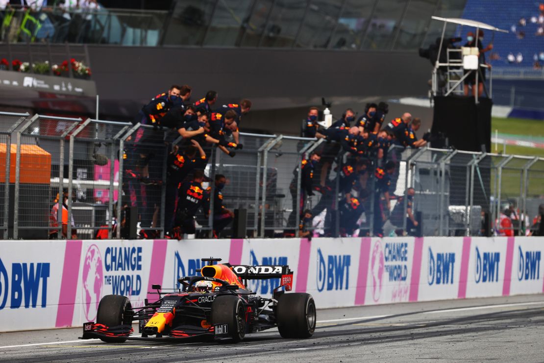 Verstappen takes the chequered flag as his team celebrate on the pitwall at the Styrian Grand Prix.