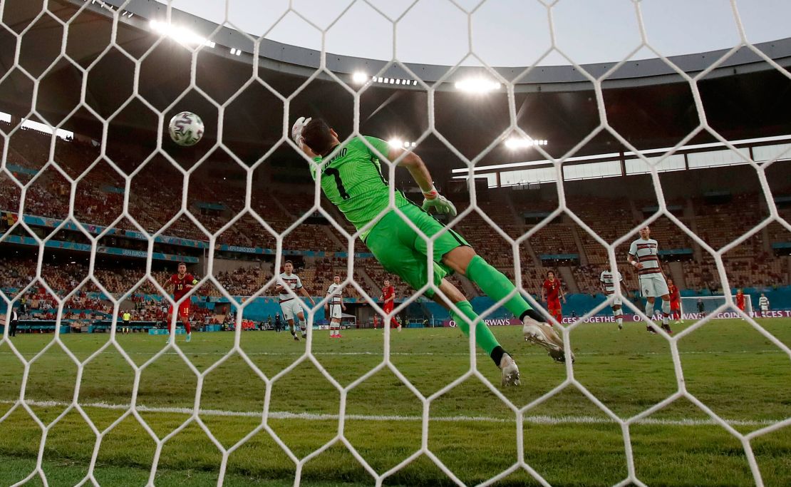 Portugal's goalkeeper Patricio fails to save the shot by Hazard.