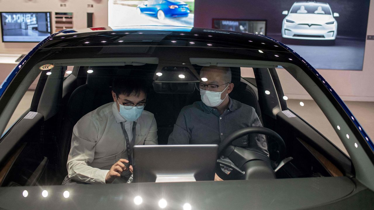 Two men sitting inside a Tesla Model 3 at a Tesla store in Beijing in May.
