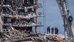 TOPSHOT - Members of the South Florida Urban Search and Rescue team look for possible survivors in the partially collapsed 12-story Champlain Towers South condo building on June 27, 2021 in Surfside, Florida. - The death toll after the collapse of a Florida apartment tower has risen to nine, the local mayor said on June 27, 2021, more than three days after the building pancaked as residents slept. "We were able to recover four additional bodies in the rubble... So I am confirming today that the death toll is at nine," Miami-Dade County mayor Daniella Levine Cava told reporters in Surfside, near Miami Beach, adding that one victim had died in hospital. "We've identified four of the victims and notified next of kin." (Photo by Giorgio Viera / AFP) (Photo by GIORGIO VIERA/AFP via Getty Images)