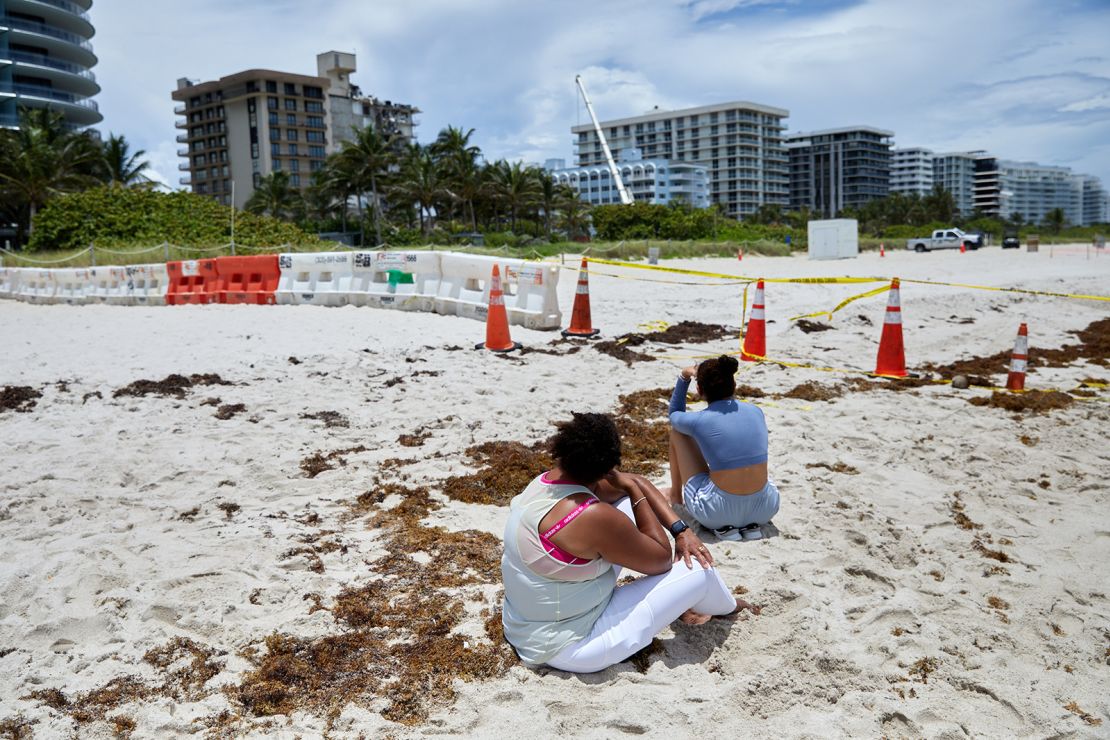 Beachgoers look at the site of the Champlain Towers South condo building collapse in Surfside, Florida. 