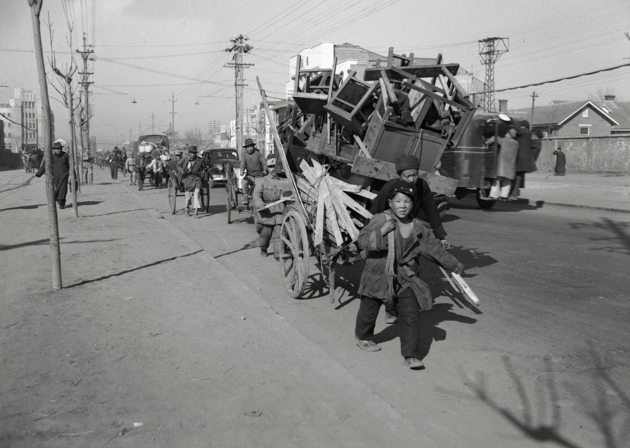 People in Nanking, China, flee with their belongings as communist forces advanced toward the city in February 1949. Nationalist armies had poured into the city for a last-ditch defense of their home base in what was then China's capital. The city fell to the Communists in April 1949.