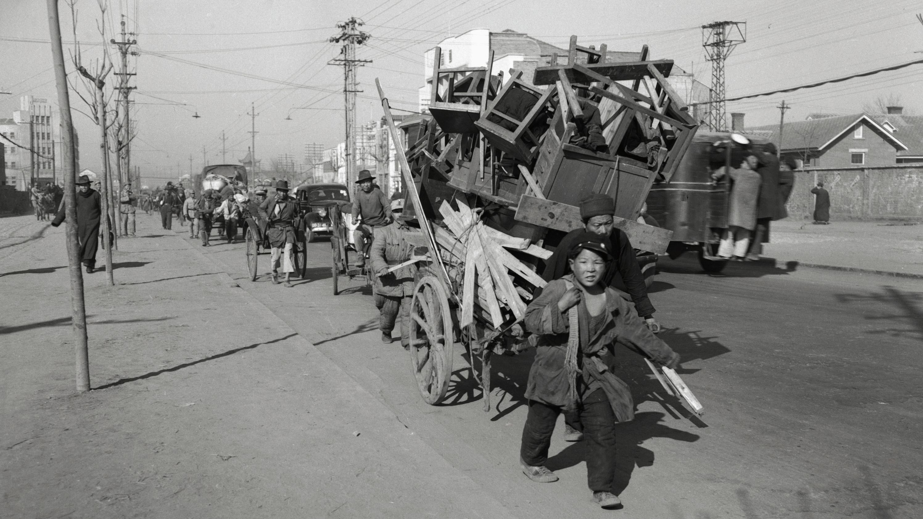 People in Nanking, China, flee with their belongings as communist forces advanced toward the city in February 1949. Nationalist armies had poured into the city for a last-ditch defense of their home base in what was then China's capital. The city fell to the Communists in April 1949.
