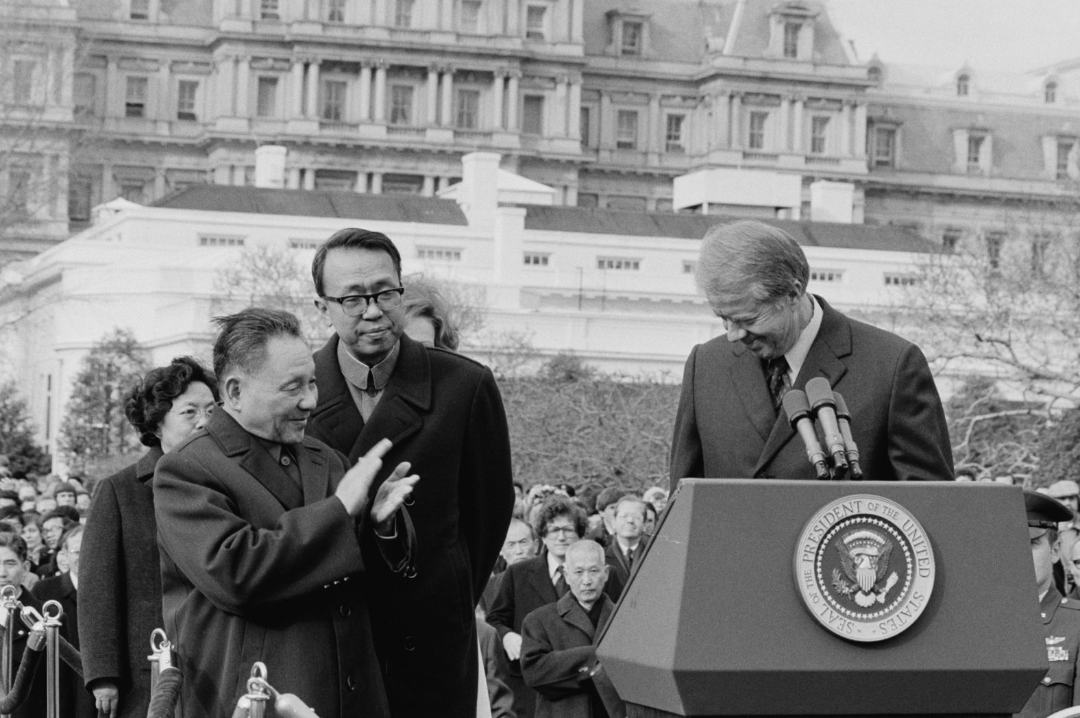 Deng applauds as US President Jimmy Carter stands behind a podium at the White House in 1979. The US officially recognized the People's Republic of China and established diplomatic relations on January 1 of that year.