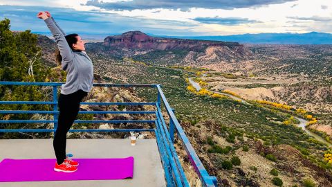 A woman stretches at an overlook in Los Alamos County, New Mexico.
