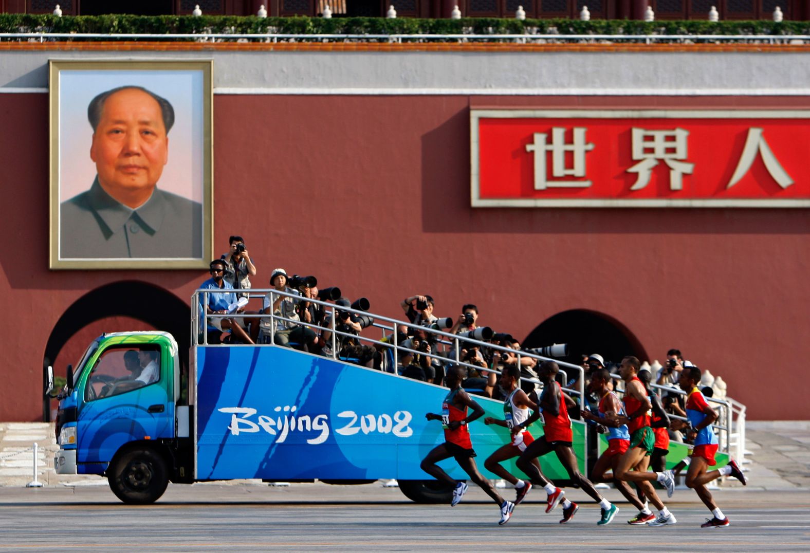 Olympians run past a Mao portrait in Beijing at the start of the men's marathon in 2008.