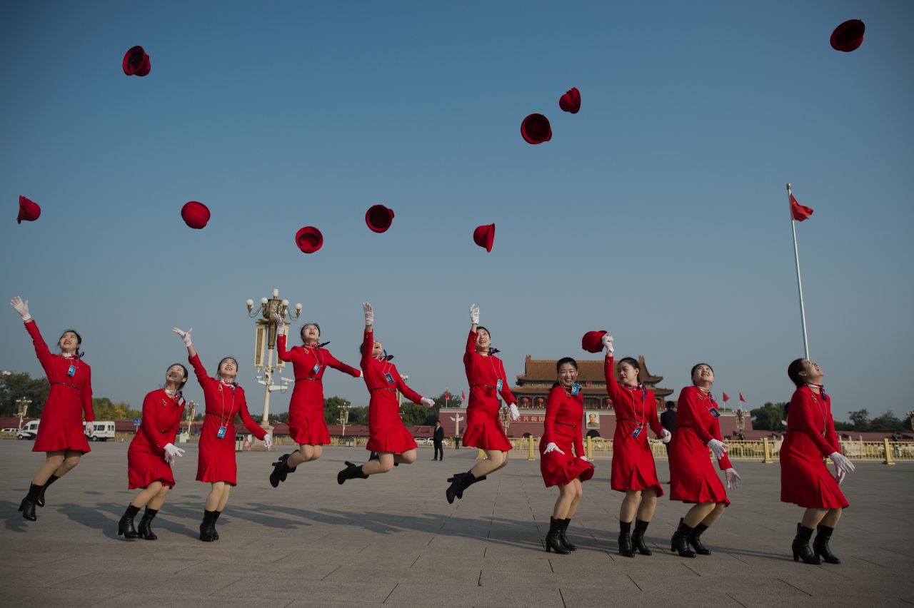 Hostesses jump in the air and throw their hats in Tiananmen Square during the closing session of the Communist Party's 19th National Congress in October 2017.