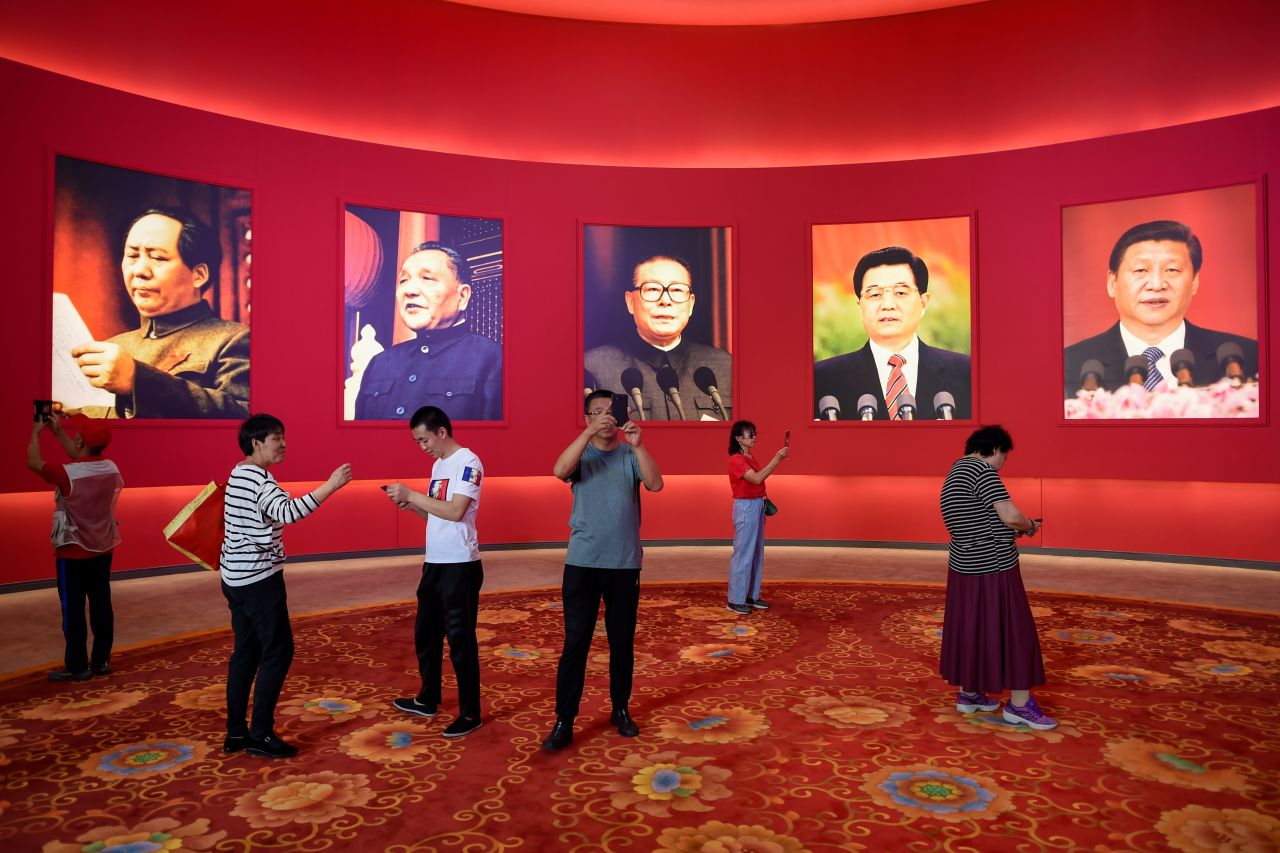 People take pictures in front of portraits of Chinese leaders during an exhibition in Beijing in September 2019. The leaders on the wall, from left, are Mao Zedong, Deng Xiaoping, Jiang Zemin, Hu Jintao and Xi Jinping.