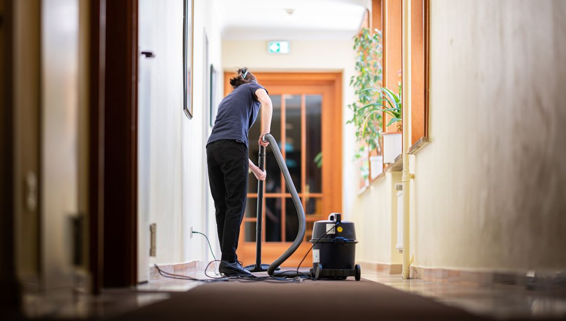A woman vacuums a hallway in a hotel on May 31, 2021, in Hamburg. Since June 1, hotels in Hamburg have been allowed to receive guests again at 60% capacity.